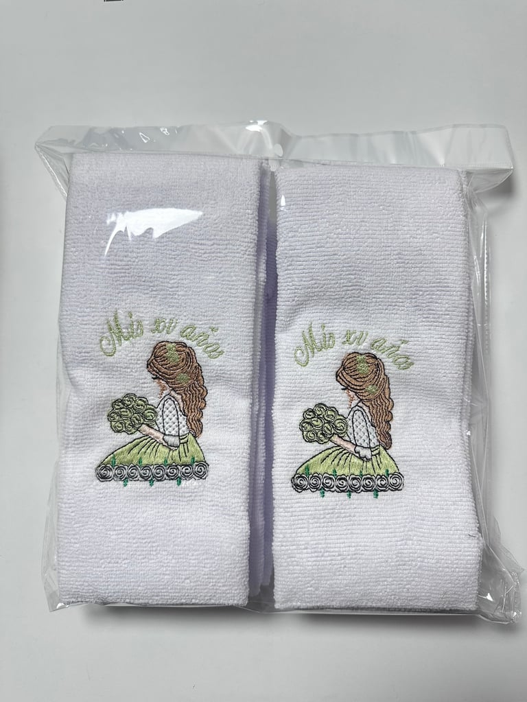 Pair of white embroidered hand towels with turtle designs in plastic packaging