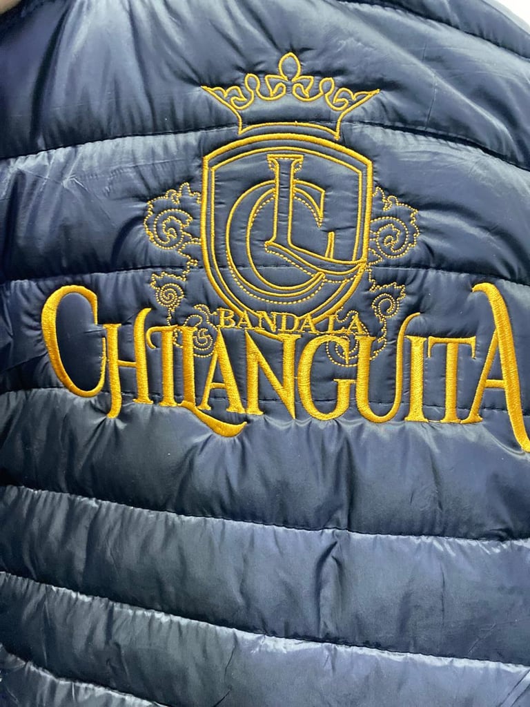 Chaqueta acolchada azul navy con corona dorada bordada y texto Banda la Chianguita