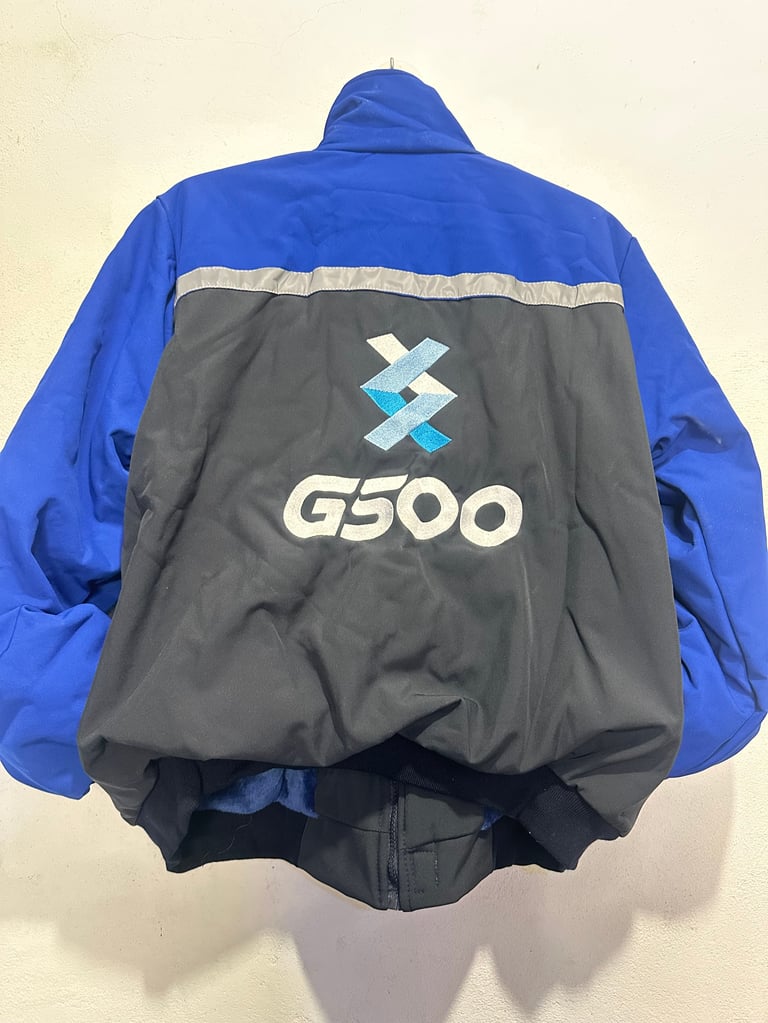 Vista trasera de chamarra G500 azul y negro con rayas reflectivas y logo