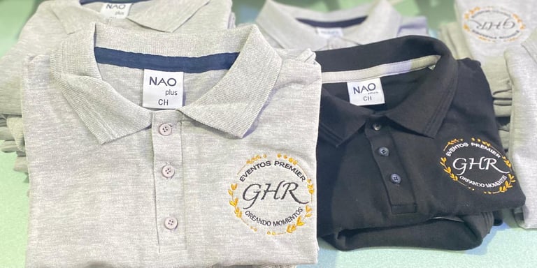 Dos playeras polo dobladas en beige y negro con bordado GHR logo una al lado de la otra