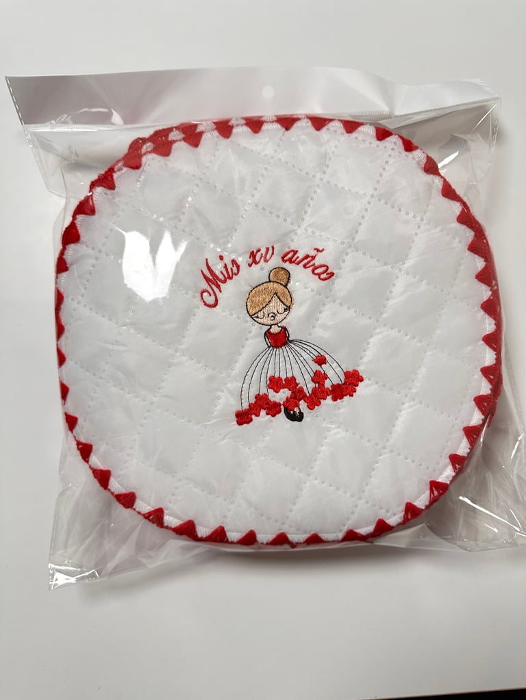 White quilted round pillow with red scalloped edge and embroidered girl design saying This so cute, packaged in clear plastic