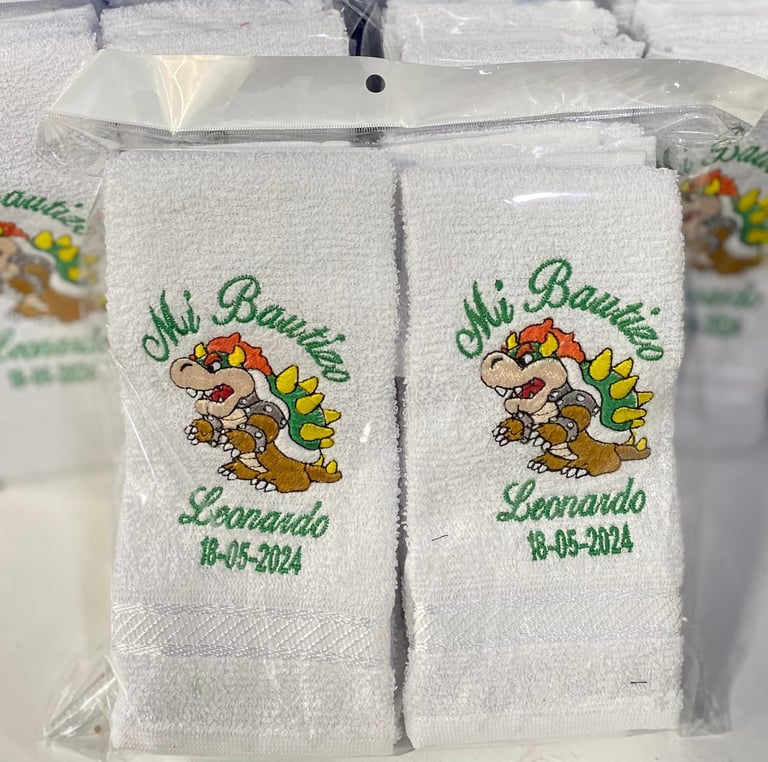 Two white embroidered towels with dragon design, Ciao Bambini Leonardo text and date 18-05-2024