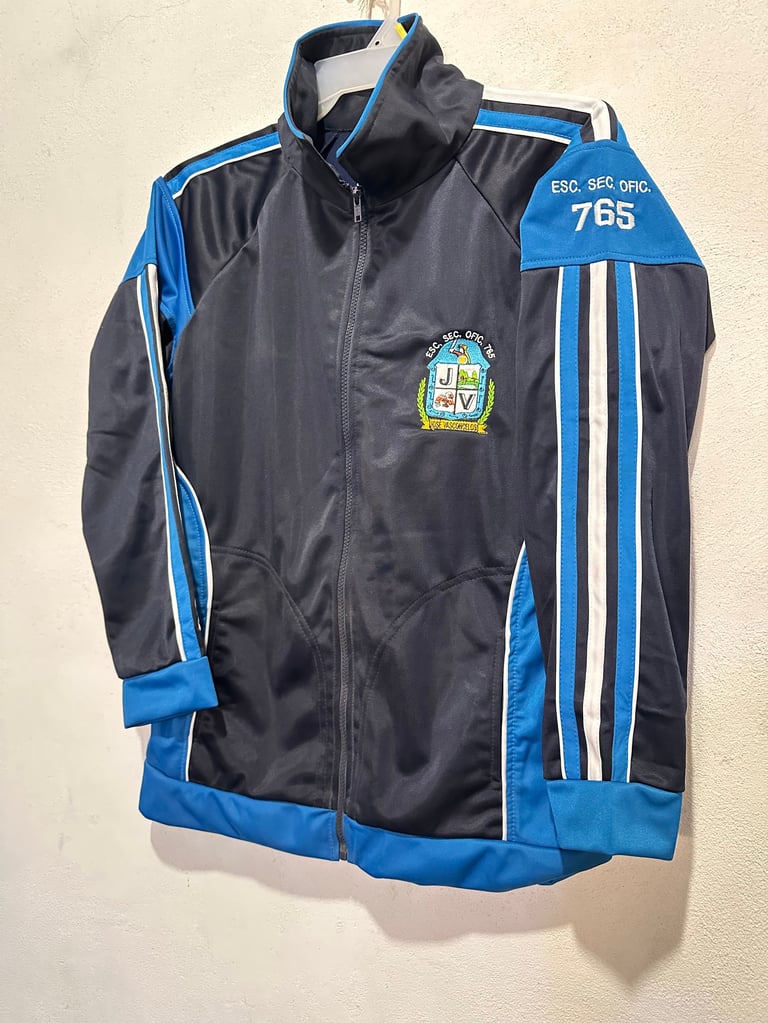Chaqueta deportiva negra y azul con rayas blancas y emblema bordado